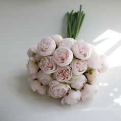 a bouquet of pink flowers sitting on top of a white table