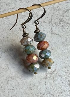 "multi color boho dangle earrings   czech glass stack earrings Four faceted Czech glass beads are stacked together along with a tiny antiqued brass bead sitting at the top. The colors are blue, ivory and pinky-orange, all with a heavy picasso coating. Hook ear wires are antiqued brass. Length of earrings from top of ear wires is 2\". Glass beads measure 5x8mm. You can enter my shop here: gypsydangles.etsy.com" Boho Earrings Diy Handmade Jewelry, Czech Glass Drop Earrings, Czech Glass Bead Earrings, Dyi Earrings, Beaded Earrings Tutorial, Czech Beads Jewelry, Pinky Orange, Stack Earrings, Earrings Handmade Boho