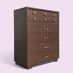 a brown chest of drawers sitting on top of a white floor next to a purple wall