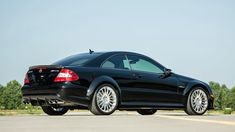 a black mercedes cls parked on the side of the road