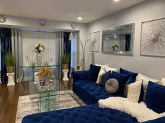 a living room with blue couches and white pillows