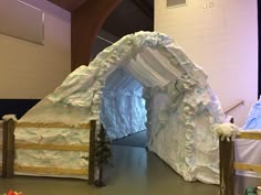 there is a fake snow covered tunnel in the middle of a room with white walls