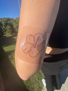 a woman's arm with a flower tattoo on the left side of her arm