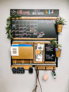 a wall mounted chalk board with magnets and potted plants