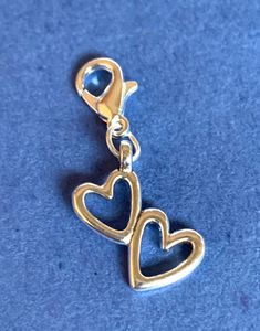 "DOUBLE HEARTS Clip on, dangle charm quality crafted in Tibetan silver. Charm measures approximately 1 1/4\" tall including basic lobster clasp. ** Please note, all charms include a basic 12mm lobster clasp as shown in photo. However, upgraded options are available. All charms can be connected to: - Basic clip-on charm with 12mm lobster clasp (as shown in photo) - Extra large lobster clasp (20mm) - Basic keyring (charm connects directly to keyring with an o-ring) - Keyring with a 1\" extension chain (charm connects to end of chain) - Keyring together with an extra large (XL) lobster clasp (charm connects on a swivel clasp to keyring) - Wineglass charm hoop (charm connects to hoop via an o-ring) - 20\" Necklace Chain with Lobster Clasp - Zipper pull (charm connects to a split o-ring for add Trendy Adjustable Charms With Lobster Clasp, Elegant Adjustable Charms With Lobster Clasp, Everyday Bag Charm With Lobster Clasp, Collectible Pendant Charms With Lobster Clasp, Heart-shaped Charms With Lobster Clasp For Gifts, Expandable Bangle Bracelet, Clip On Charms, Hoop Charms, Double Heart