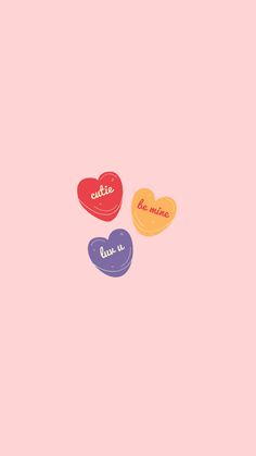 three heart shaped candies on a pink background