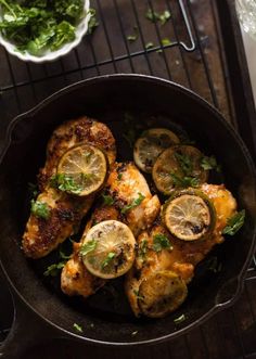 chicken with lemons and herbs in a cast iron skillet