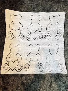 a white crocheted doily with black dots on it sitting on the floor