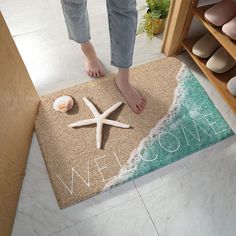 a person standing on a welcome mat with seashells and starfish