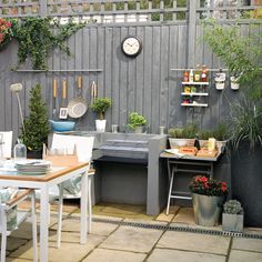 a screen shot of a small patio with potted plants on the wall and an outdoor dining table