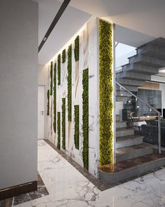 the interior of a modern building with marble floors and walls covered in green plant life