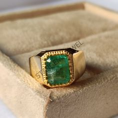 a gold ring with a green stone in it