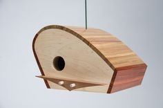 a wooden bird house hanging from a wire