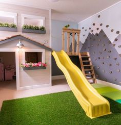 a child's playroom with a slide, climbing wall and flower boxes on the walls