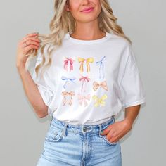 Looking for a cute versatile top to wear? Make sure to grab one of our Graphic tees! This soft and comfortable graphic tee is the perfect top for any outfit. It can be paired with biker shorts, jeans, or even a simple skirt/dress! This tee is true-to-size, so be sure to order your regular t-shirt size! If you are looking for a more oversized look, make sure to size up! Cute Spring Tops With Screen Print, Cute Tops With Screen Print For Spring, Cute Screen Print Tops For Spring, Spring Funny Print Graphic Tee, Funny Print Graphic Tee For Spring, White Top With Funny Print For Spring, Cute White T-shirt For Spring, Cute Pre-shrunk Spring T-shirt, Cute Pre-shrunk T-shirt For Spring