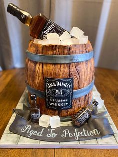 A marble cake wrapped in wood grain fondant, with a real bottle of Jack Daniel’s on top. The cake board and ribbon are fondant as well, and the label is edible! Whiskey Barrel Cake, Whisky Cake, Birthday Beer Cake, Cake Design For Men, Barrel Cake, Whiskey Cake