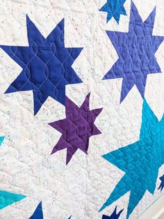 a blue and purple quilt with stars on it