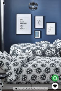 a bedroom with blue walls and soccer balls on the bed