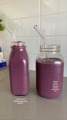 two mason jars filled with purple smoothie next to each other on top of a counter