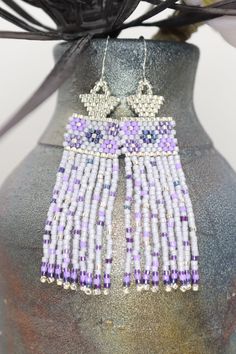 Swoon worthy sweet lavender, purple, and silver boho seed bead earrings featuring a dainty flower pattern with confetti on the swaying fringe. They were inspired by a beautiful bouquet I saw, and I wanted to share that beauty and the happiness the colors brought me with you. These are OOAK. Handmade by me in my home studio.Size 2 7/8 inches long5/8 inch wide2 1/4 inch drop Lavender Seeds, Seed Bead Jewelry Patterns, Mermaid Earrings, Purple And Silver, Artisan Earrings, Jewelry Beaded, Best Gifts For Her, Handmade Jewelry Designs, Lavender Purple