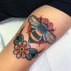 a bee and flower tattoo on the arm