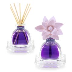 two purple bottles with sticks in them sitting next to each other