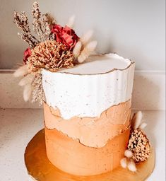 a white and orange cake with flowers on top