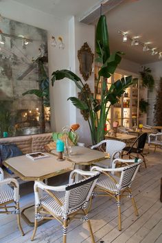 a table and chairs in a room with plants on the wall behind it, next to a couch