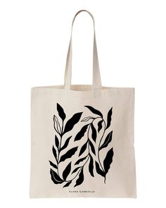 a black and white tote bag with leaves on the front, featuring an image of a