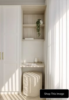 a room with white walls and wooden flooring next to a shelf filled with books