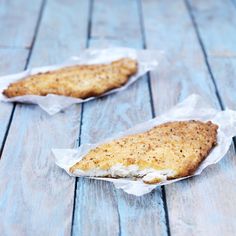 two fish fillets sitting on top of a wooden table