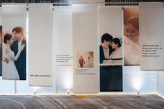 a couple kissing each other in front of some white wall hangings with pictures on them