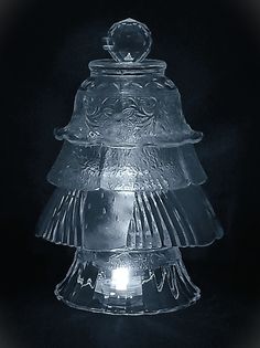 a clear glass cake dish on a black background