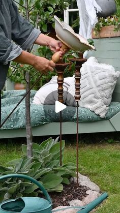 a man is working on an outdoor table top garden sculpture in the yard with his hands