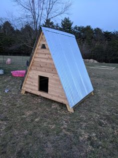 a small wooden house with a metal roof and a blue tin sheet on the top