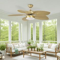 a living room filled with furniture and a fan on top of a wooden table next to a window