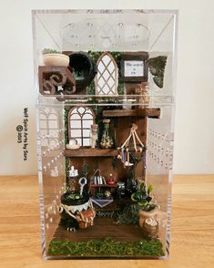 a display case with many items in it on a wooden table and wood flooring