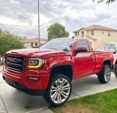 a red truck is parked in front of a house