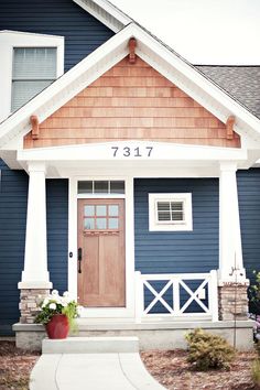 a blue house with white trim and brown door is featured in this ad for real estate