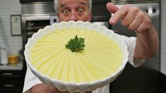 a man holding a pie pan with a green sprig on it