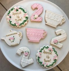 decorated cookies are arranged on a plate with the words, name and teapots