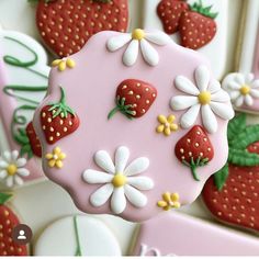 the cookies are decorated with strawberries and daisies