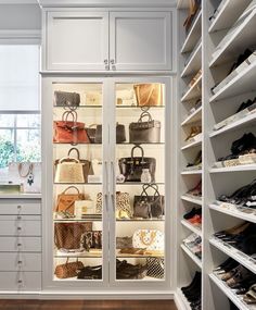 a walk in closet with lots of purses and handbags on the shelves next to it