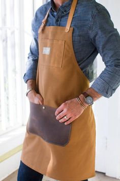 a man wearing an apron holding a leather bag