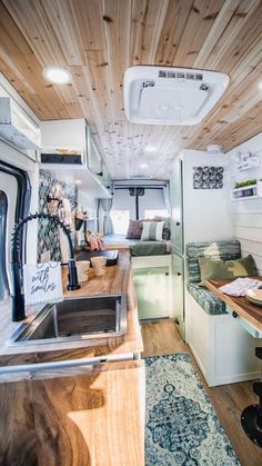 the interior of an rv with wood paneling on the walls and ceiling, along with a kitchen island