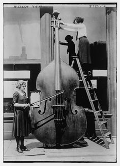 an old black and white photo of two women standing next to a giant contraption