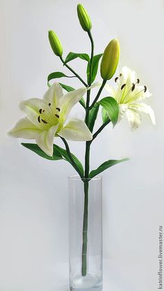 a glass vase filled with white flowers on top of a table