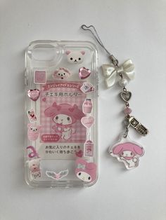 an iphone case with hello kitty stickers on it and a keychain attached to the back