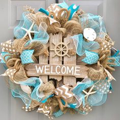 a welcome sign is attached to a door with burlocks and sea shells on it