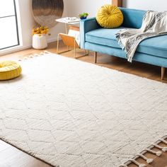 a living room with a blue couch and white rug